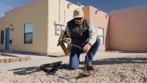 City employee lifting the cover off of the water meter showing there are wires attached