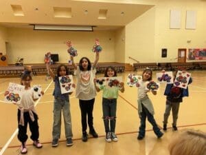 Kiddos holding up art standing side by side