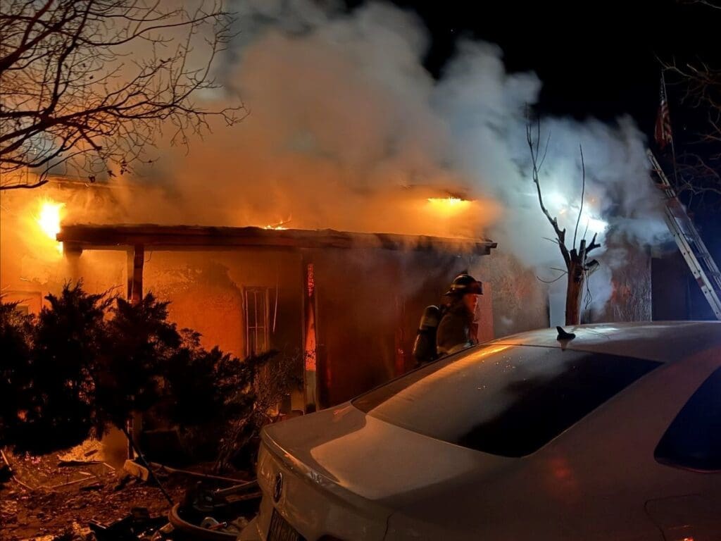 Fireman standing in front of a burning house.