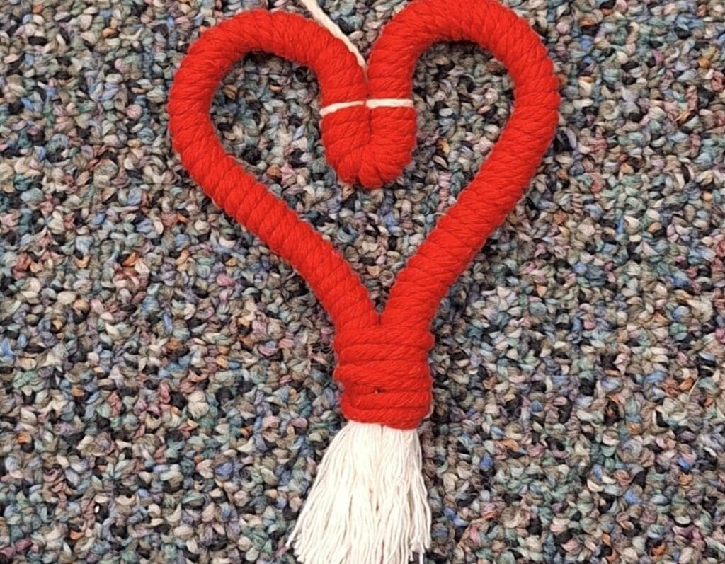 A red heart shape made of yarn