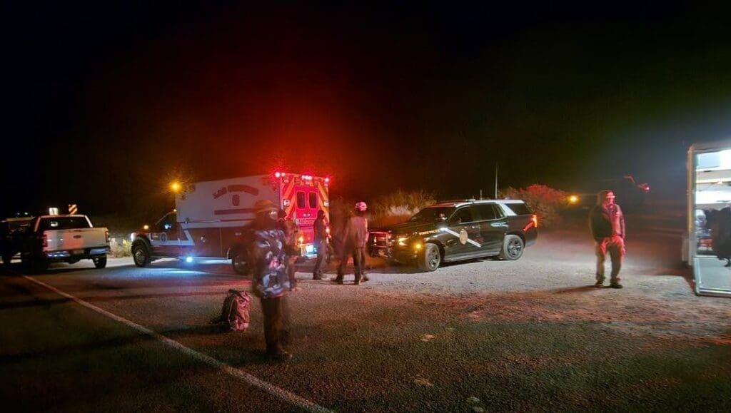 Rescue vehicles parked by the side of the road at night.