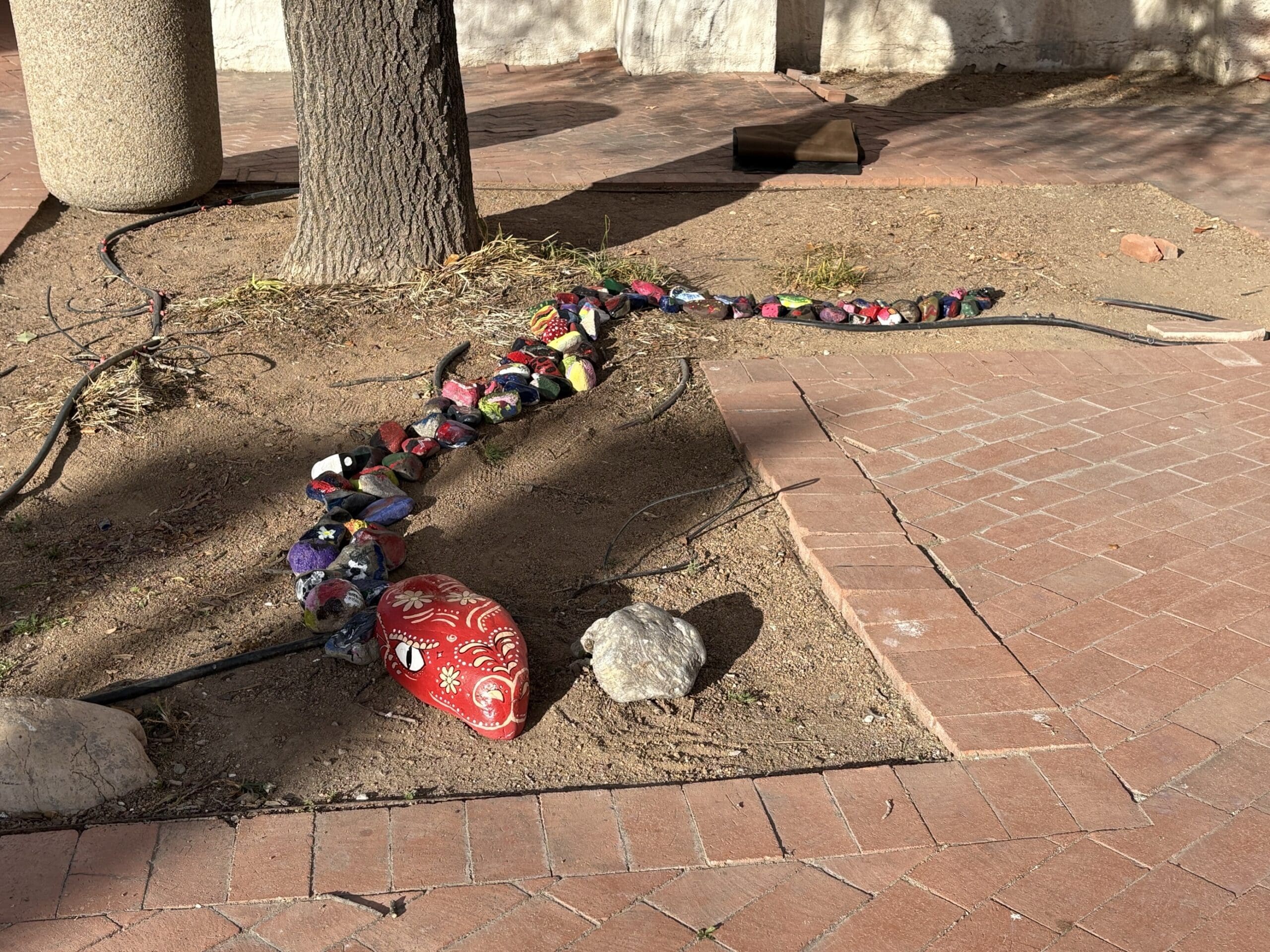 Rock snake in ground under tree
