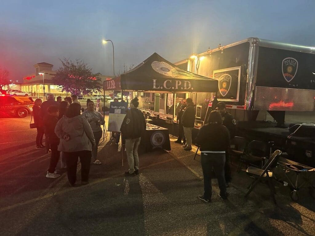 Police Officers engaging with community members outside in the evening.