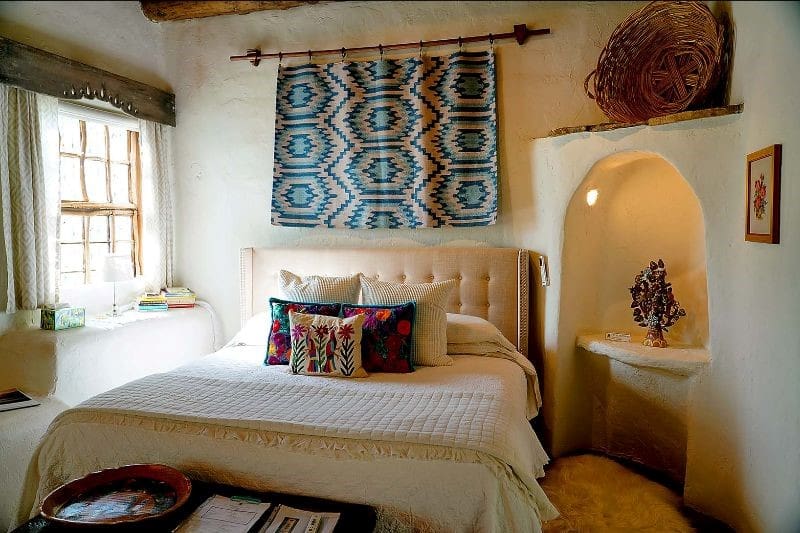 Bedroom with a bed and wall hanging and a window.