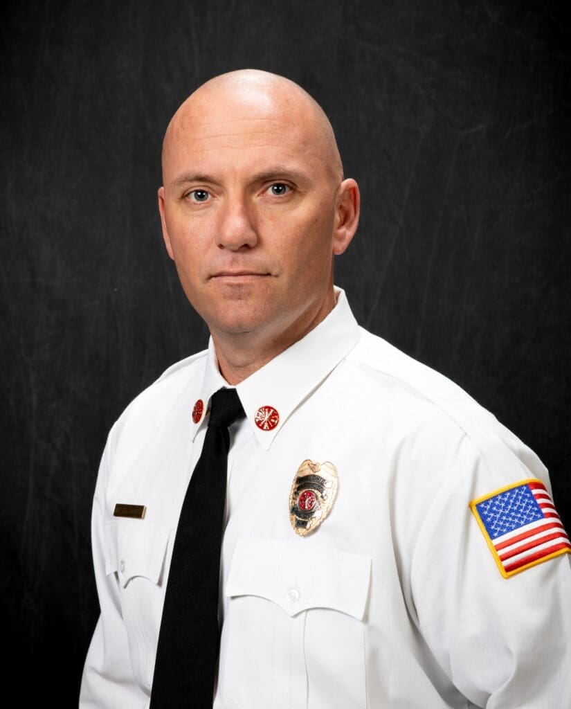 Photo of Michael Daniels, LCFD Fire Chief in white shirt and tie