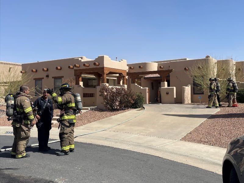 Firefighters standing in front of a house.