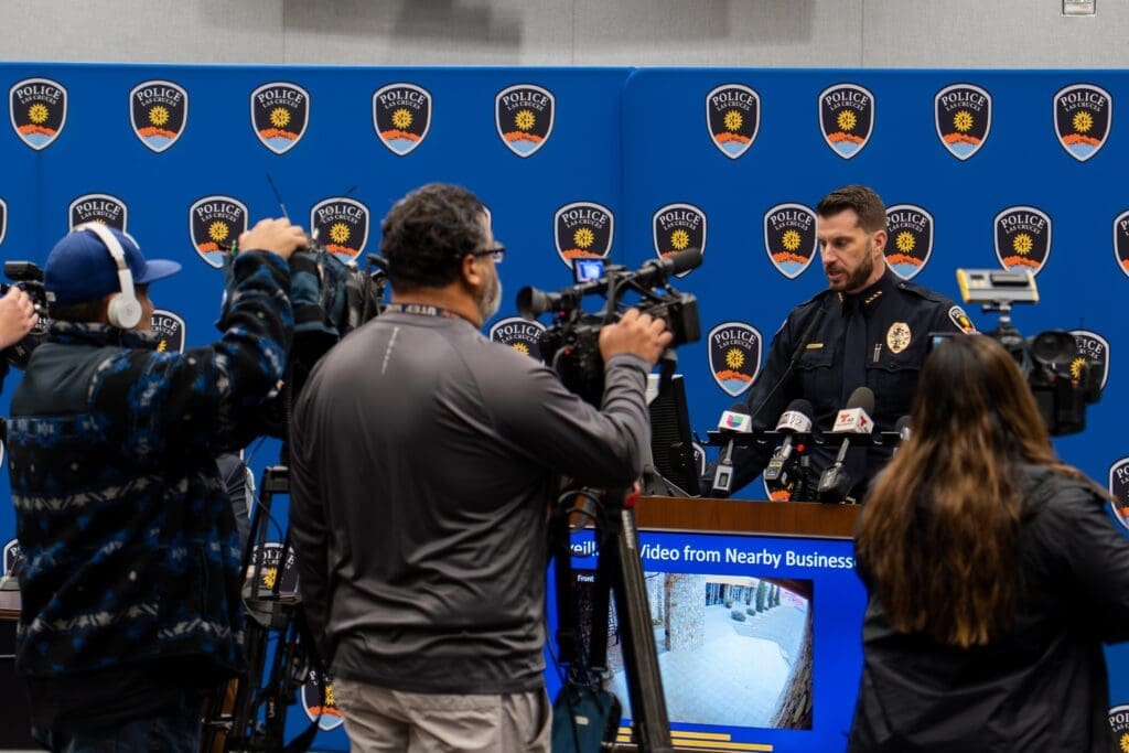 Camera men speaking to police chief.