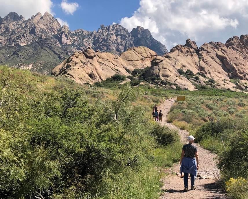 Group of hikers walking along a trail near the Organ Mountains