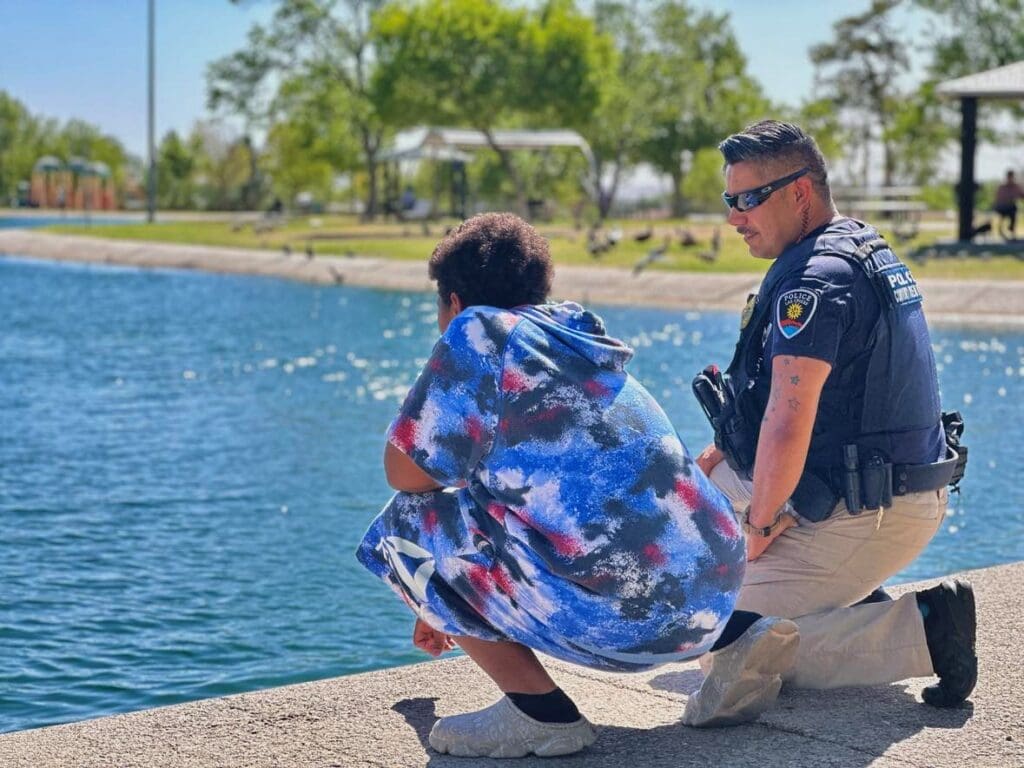 Police officer and child looking into a pond