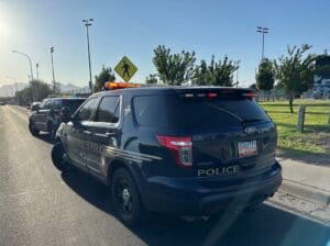 Two police cruisers parked on the side of the road.