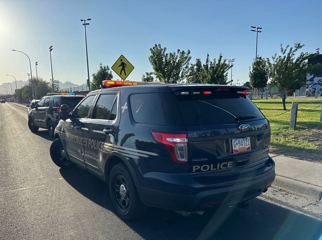 Two police cruisers parked on the side of the road.