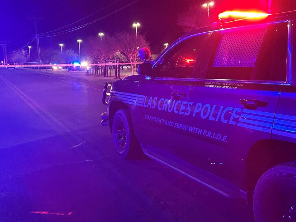 Police vehicle parked with lights on at night.