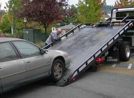 Tow truck picking up a car.