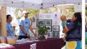 People interacting under a pop up tent