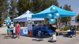 People standing near pop up tents outside with balloons