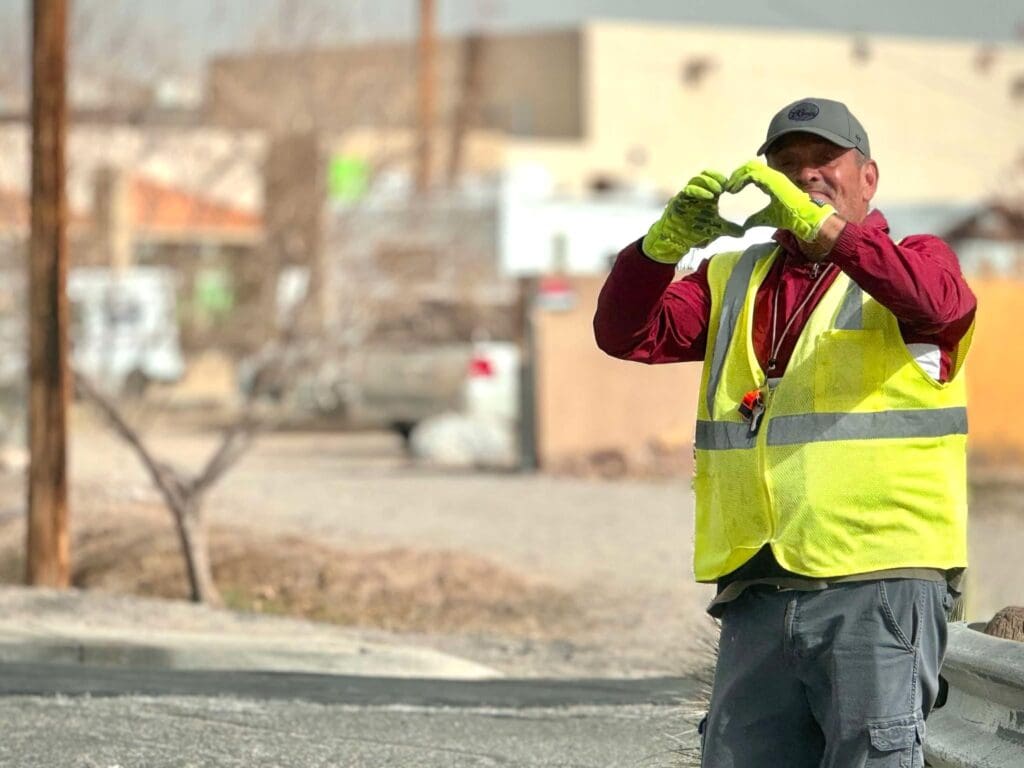 School crossing guard making a heart shape with his hands.