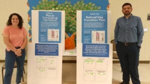 a female on left and male on right with information in between on poster boards describing elements the Natural Gas Transition Plan.