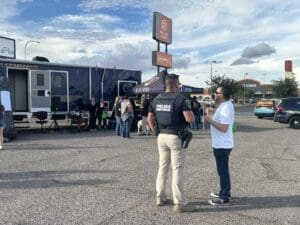 Police officer talking to someone in a parking lot.