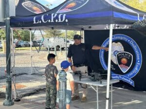 Police Office under a tent talks to young kids about the drone program.