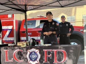 Las Cruces Firefighters stand underneath a tent to engage the community.