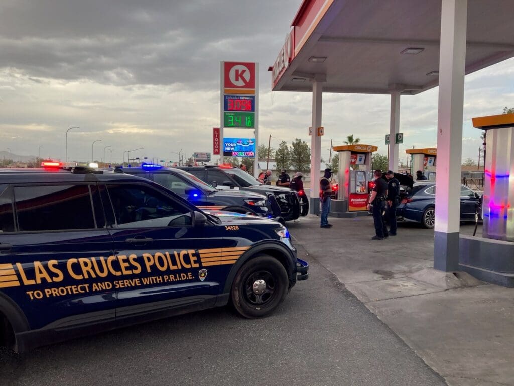 Three police vehicles parked at Circle K with their lights on.