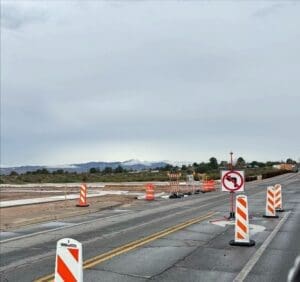 Road work signs and cones on a road.