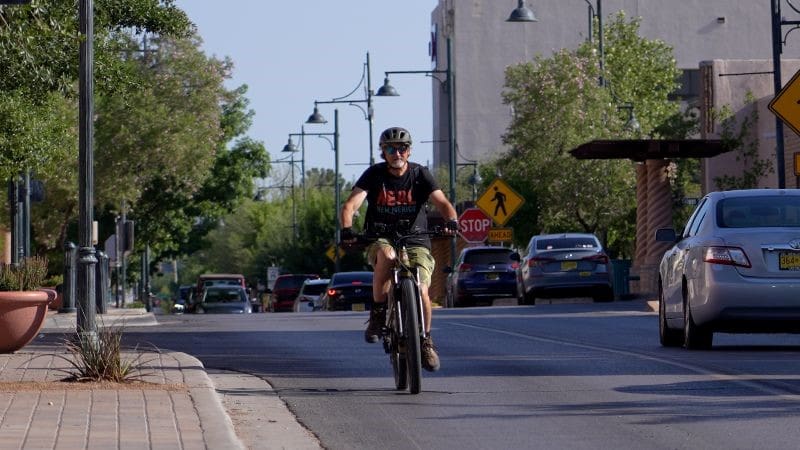 Bicyclist riding down a street.