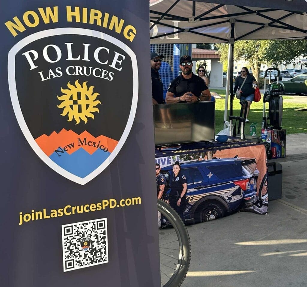 Las Cruces Police Department now hiring sign in front of a recruiting table,