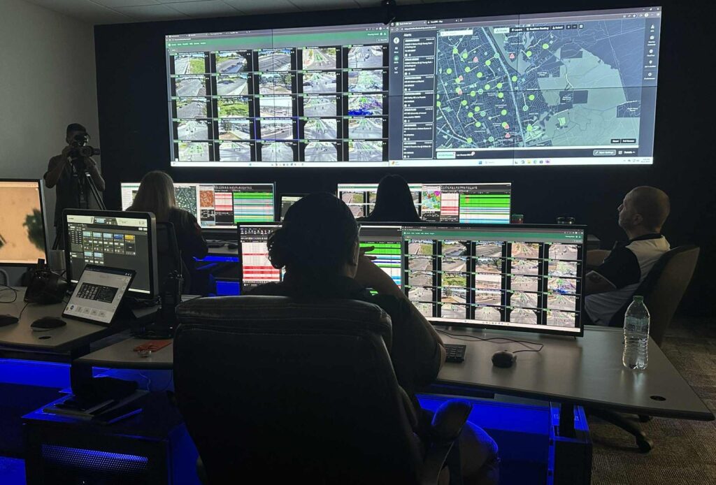 People working on computers at desks in a dark room.