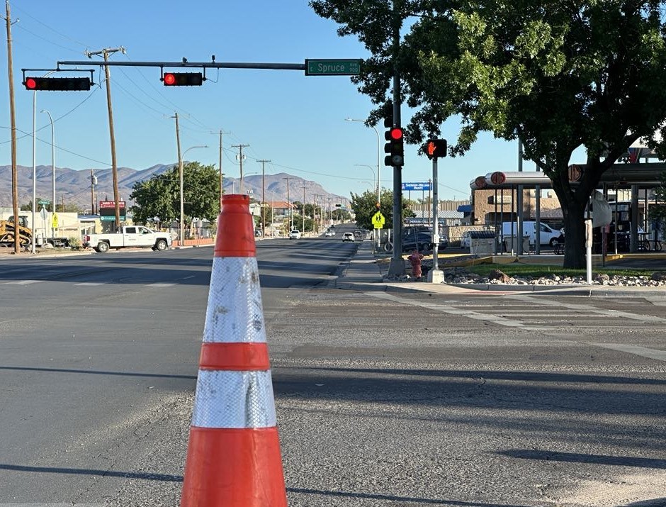 A traffic cone in the street at an intersection.