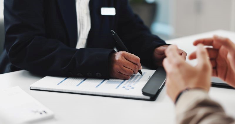 A person filling out an application at a table.
