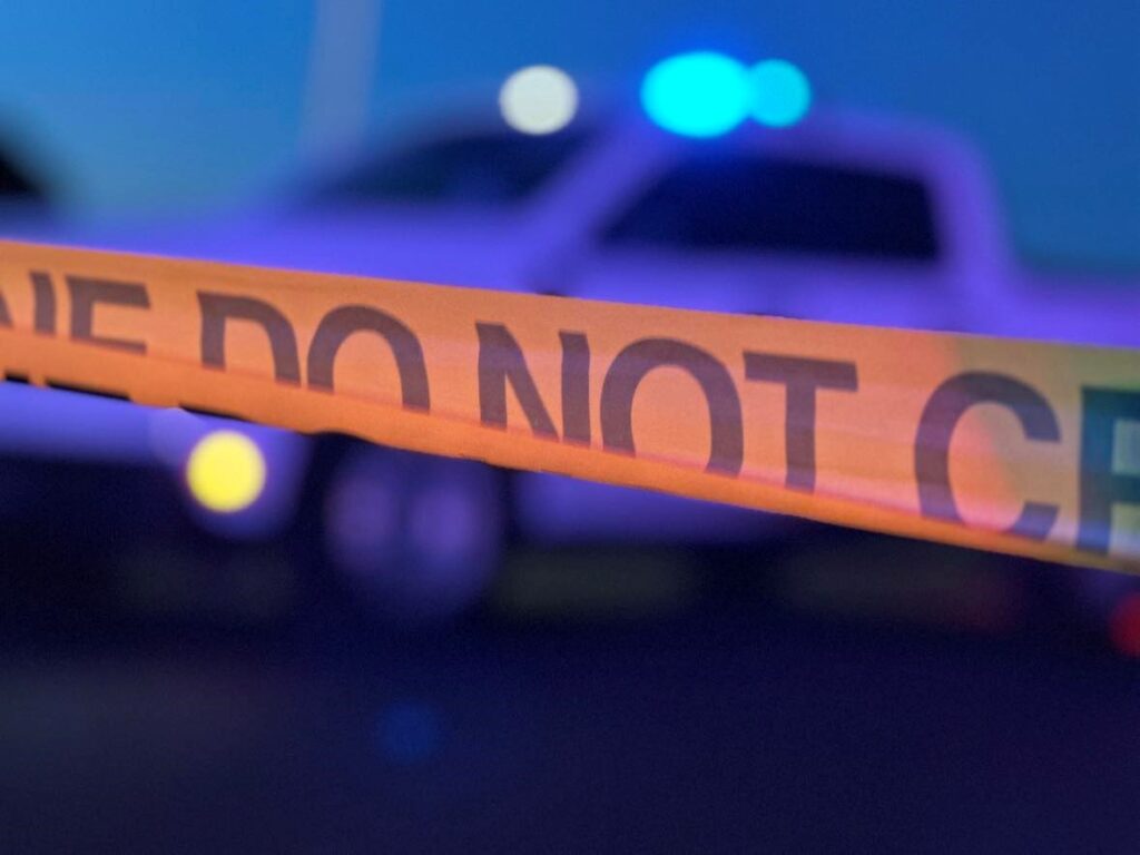 Crime scene tape in front of a truck.