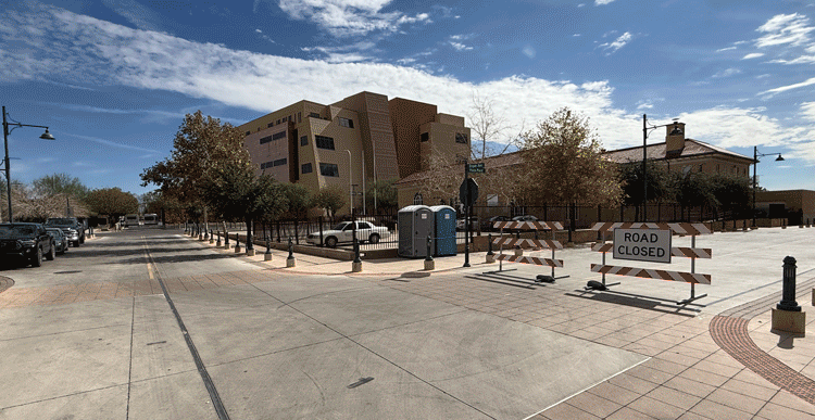 A gif first showing the side of the Downtown plaze with "road closed signage", and an empty gated area. The gif then transitions to an illustration of a two story building that is foreseen to be in this location.