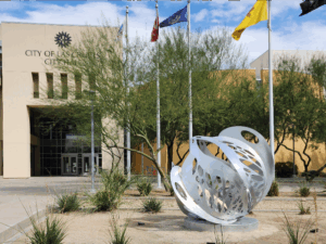 A round sculpture placed in front of the flag poles at City Hall.