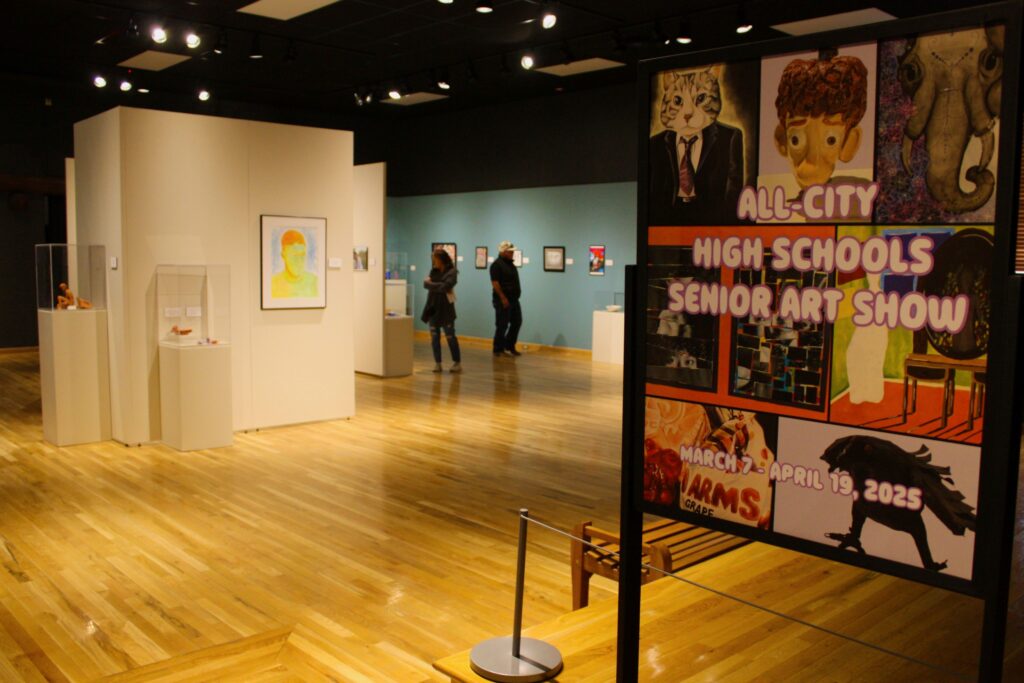 People in a museum looking at artwork hung on the walls.