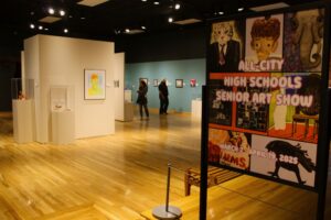 People in a museum looking at artwork hung on the walls.