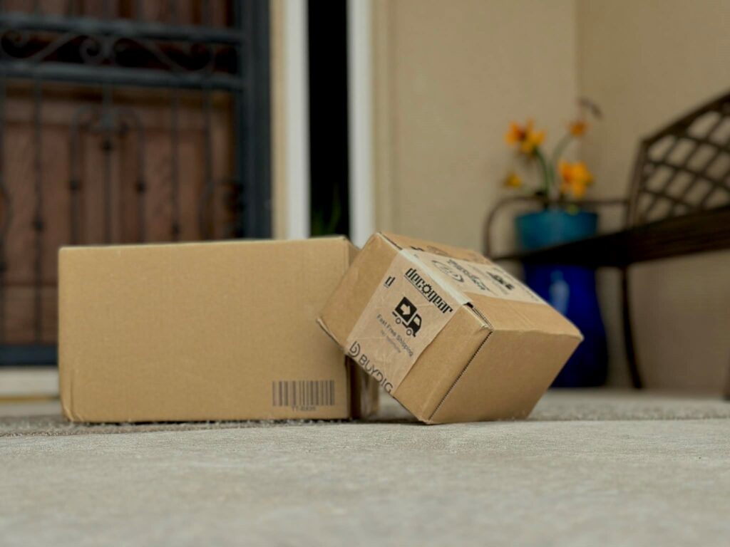 Two boxes on the ground with a bench in the background.