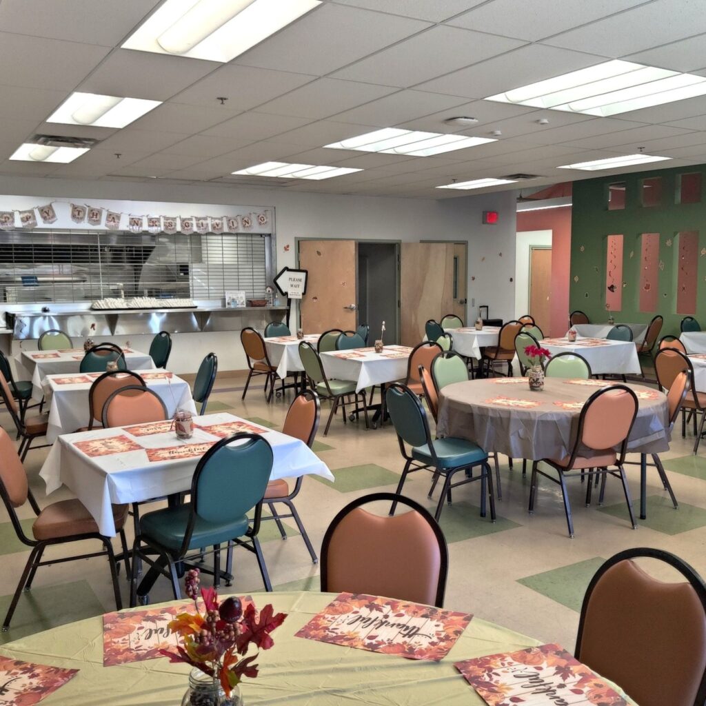 Cafeteria area with tables and chairs set up for Thanksgiving,