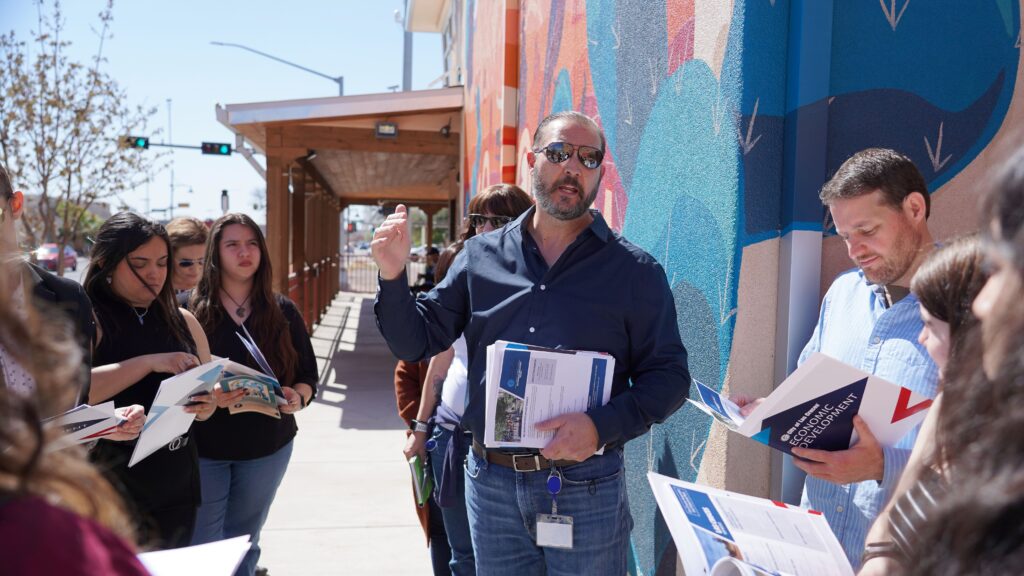 Department director speaking with a group of people outside of a City building.