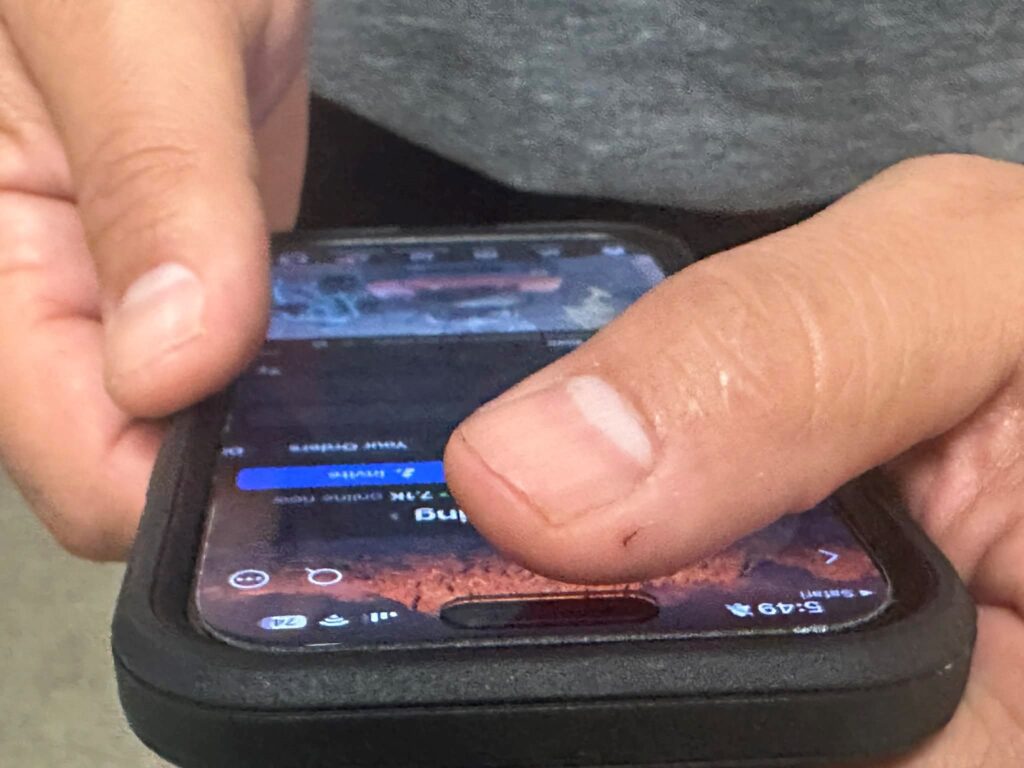 Hands holding a cell phone.