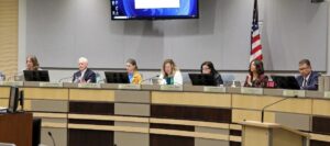 Six city councilors and mayor sitting behind a desk.