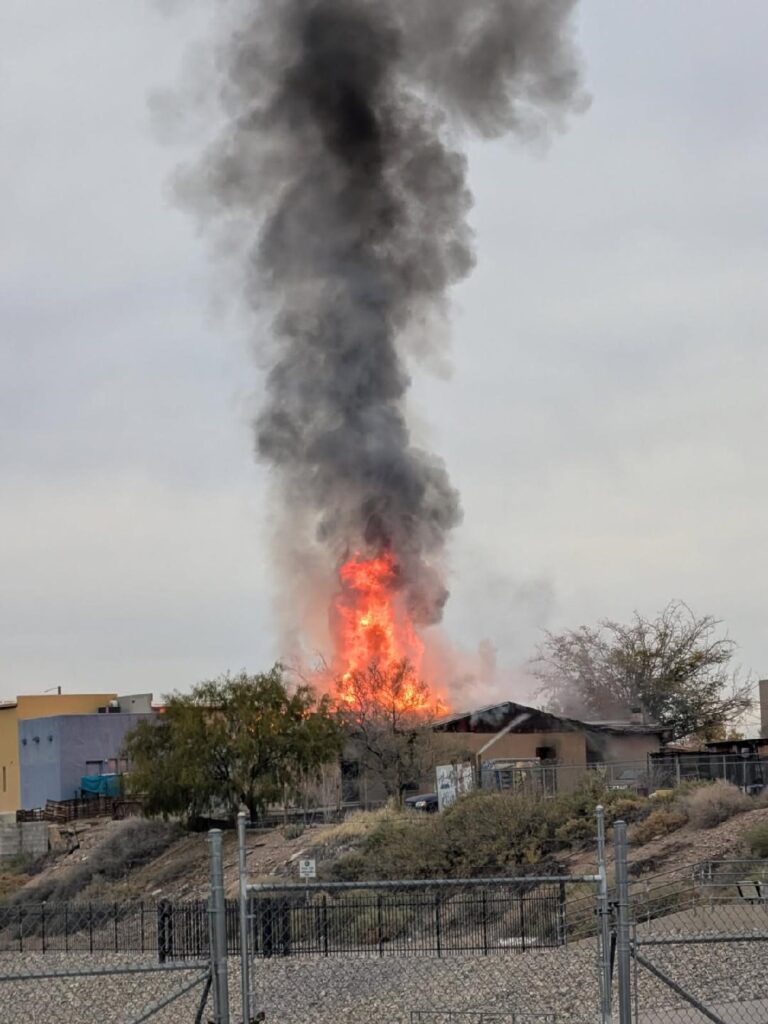 House structure with flames and black smoke coming from it.