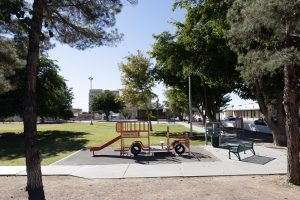 View of Klein Park with the fire truck playground equipment and the stage in the far background.
