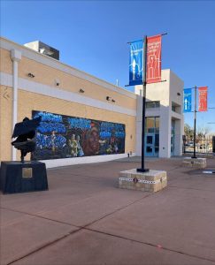 Exterior wall of the Las Cruces Museum of Art with a painting on the wall.