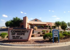 Photo of the front sign of Community of Hope in las Cruces with the building in the background.