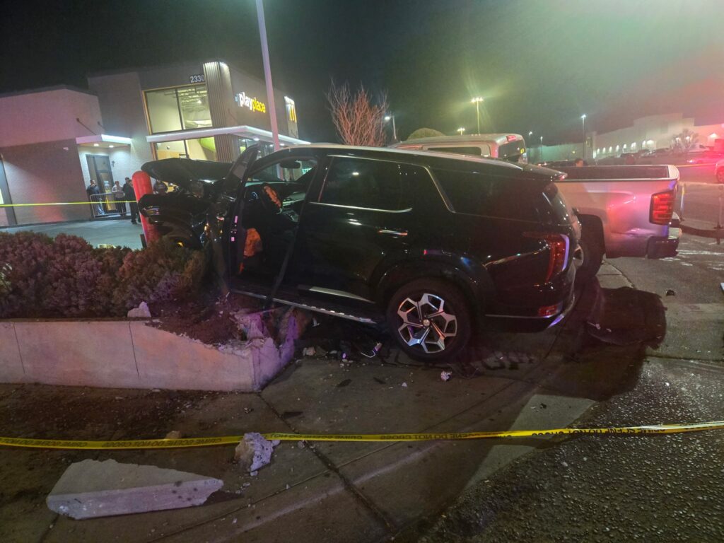 Two vehicles that collided and landed on a sidewalk.