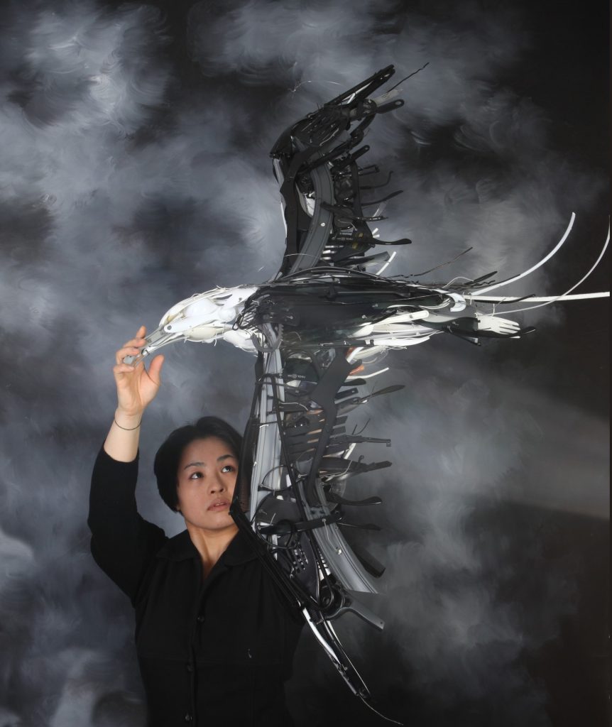 A woman holding a sculpture of an eagle.