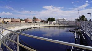 City of Las Cruces wastewater treatment facility tank with liquid inside and railing surrounding the tank.