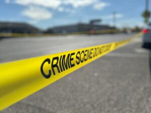 Crime scene tape put up by a road.