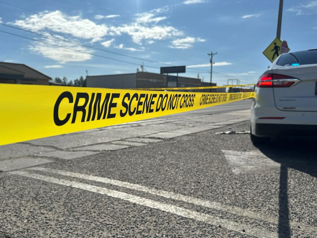 Crime scene tape displayed in a parking lot.